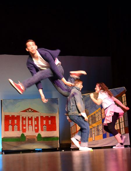 Sam Ritter leaps across stage as Chase Techentin and Kristen Voorhies dance in the background during the performance with the independent group "There and Back Again" at the 14th annual Variety Show. - Photo by Abigail Harris