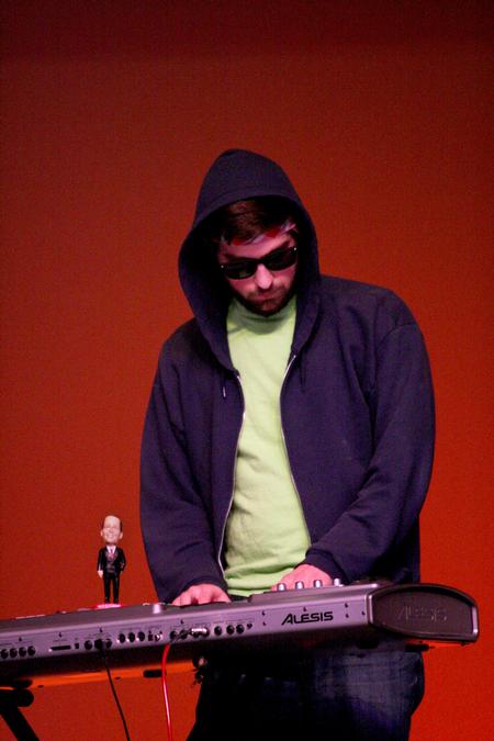 Stephen Capps, junior biblical studies major, plays the keyboard with the Dr. Dockery bobble head on top at the 14th annual Variety Show. - Photo by Deanna Santangelo