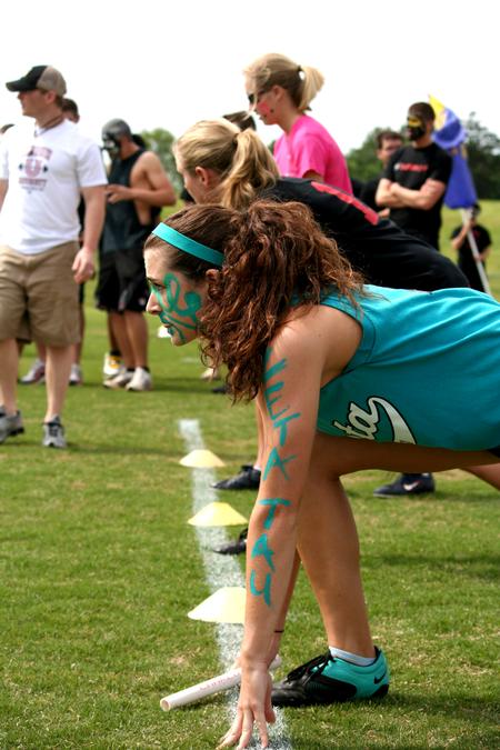 Megan Daniel, junior nursing major, crouches with anticipation at the starting line for the baton pass at the Greek Olympics. - Photo by Deanna Santangelo