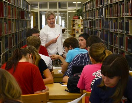 Pam Sutton, professor of English, helps students with an assignment in the Emma Waters Summar Library.  - Photo by Victoria Stargel