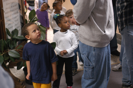 A group of young students at Parkview Montessori look inquisitively at these tall people who have come to volunteer their time and energy to work with them during Day of Remembrance 2003. - Photo by Jonathan Blair