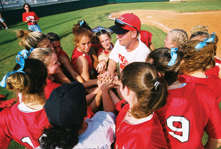 Coach Brian Dunn huddles up with the Lady Bulldog softball team. - Photo by Jim Veneman