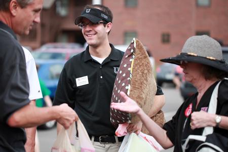 Landon Preston (center), director of donor relations, gathers things from a new student's car during New Student Move-in.  - Photo by Kristi McMurry Woody