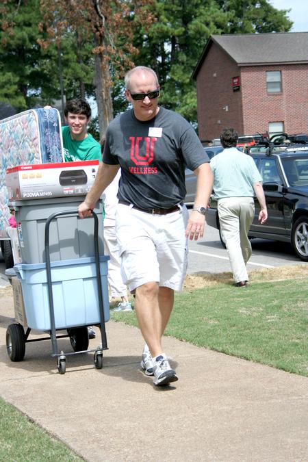 Andy Madison, associate professor of biology, and Michael O'Malley, senior English major, carry items to a room during New Student Move-in. - Photo by Deanna Santangelo