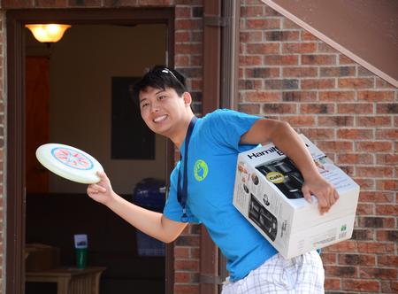 James Lui, junior psychology major, plays frisbee as he helps freshmen move into their new rooms for New Student Move-in.  - Photo by Zac Calvert
