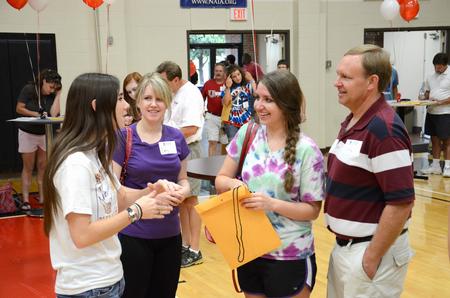 Ali Jeffries, freshman, talks with Gretchen Endres, freshman nursing major, and her family during registration for New Student Move-in. - Photo by Jacob Moore