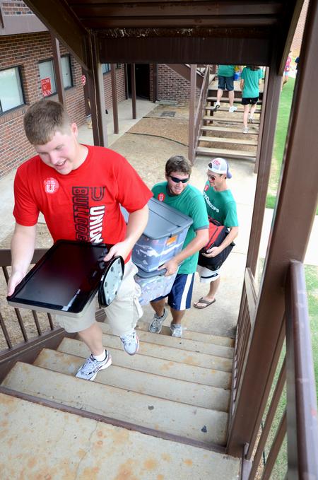 Travis Cross, sophomore physics major, leads a group of students helping new students moving into the Heritage Complex during New Student Move-in. - Photo by Jacob Moore