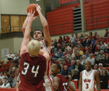 Freshman center Ben Frederick (54) takes a shot over a Lyon College defender.  Union's Chima Abakwue (3) looks on. - Photo by Jonathan Blair