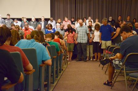 New students and their families join hands during a prayer over the new students and the beginning of their college experience in the GM Savage Memorial Chapel. - Photo by Jacob Moore