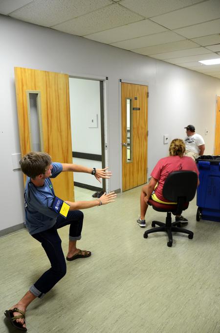 Kirby Lewis, junior chemistry major, helps freshmen in a rolling chair race during Focus week. - Photo by Zac Calvert
