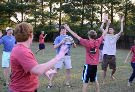 Lucas Littleton, senior biology major, looks for a teammate to pass a frisbee to during the annual ice cream social outside the home of David and Lanese Dockery. - Photo by Jacob Moore