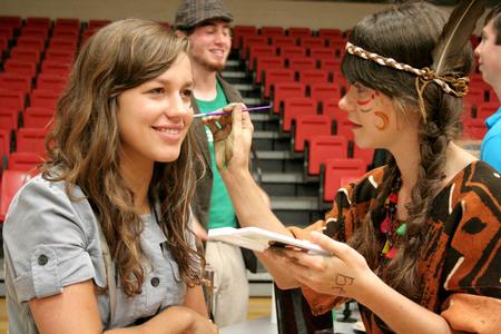 Chelsea Meiss, freshman sociology and intercultural studies major, has her face painted by Ellen Cline, sophomore art major, during the LifeGroup presentations for new students. - Photo by Deanna Santangelo