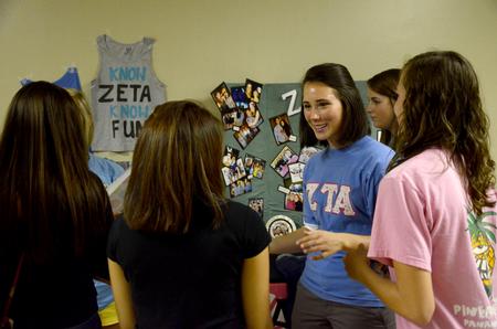 Lily Coursey, junior elementary education major, encourages incoming freshman girls to rush during Greek recruitment at the Student Activity Fair. - Photo by Ebbie Davis
