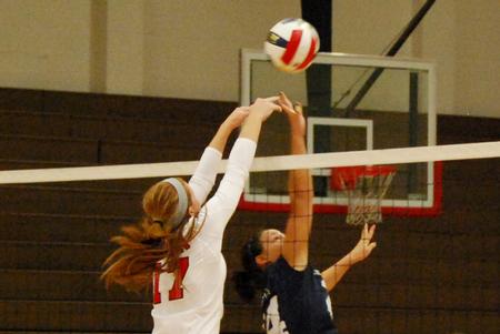 Anna Sims tips the ball against a Lyon College defender.  - Photo by Anne Richoux