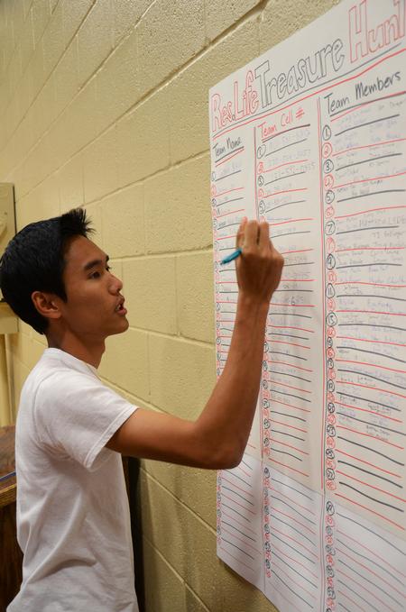 James Vo, freshman chemistry major, signs his team up for the Resident Life Treasure Hunt across campus. - Photo by Zac Calvert