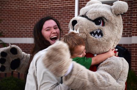 Mindy Winters, sophomore psychology major hugs Buster the bulldog during the Make-a-wish cookout for Family Weekend.  - Photo by Zac Calvert