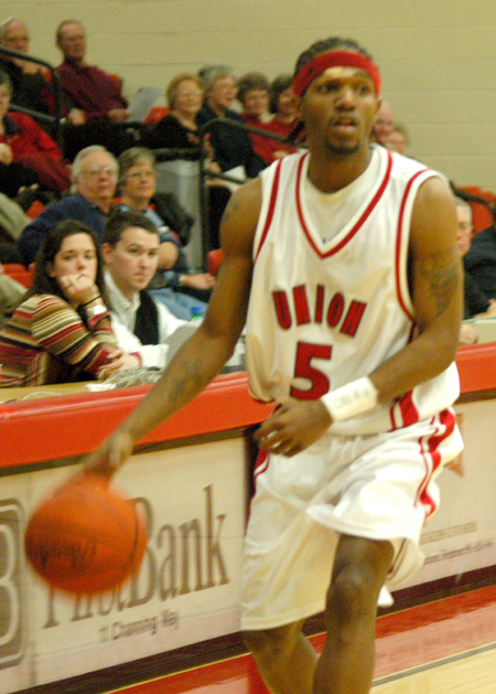 Union's freshman point guard Marcus Cooper (5) surveys the defense as he moves the ball up the floor. - Photo by Courtney Ross