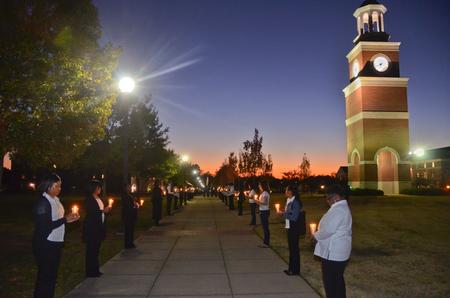Social Work students hold candles to honor the families who have lost loved ones to homicide at the the fourth annual Remember Me Walk hosted by the social work department. - Photo by Morris Abernathy
