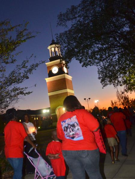 Union students and friends hold candles to honor the families as they walk by during the the fourth annual Remember Me Walk.  - Photo by Morris Abernathy