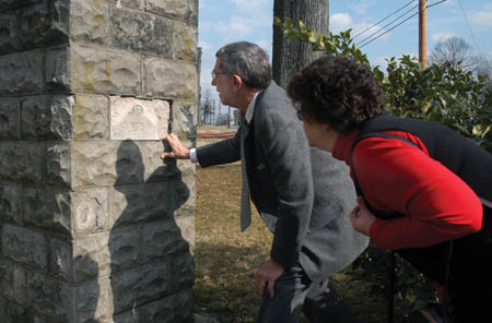 King Jamison (’52) and Nancy Dismuke (’54) attempt to make out words etched on the original Union gate during a Homecoming visit to the former Union University campus and historic downtown Jackson.  - Photo by Jim Veneman