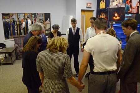 David Burke, professor of theatre and director of the theatre, prays with the Union Players prior to their performance of "The Importance of Being Earnest" on opening night.  - Photo by Anne Richoux