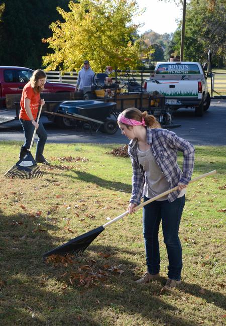 Julie Hembree (front), sophomore art major, and Maddie Russo, senior learning foundations major, rake leaves at Pleasant Plains Baptist Church during the ninth annual Campus and Community Day. - Photo by Jacob Moore