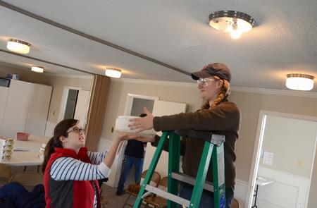 Kate Allen and Amanda Chambers, senior art majors, clean out light fixtures at Pleasant Plains Baptist Church during Campus and Community Day, an annual event where the Union community does service projects around Jackson. - Photo by Jacob Moore
