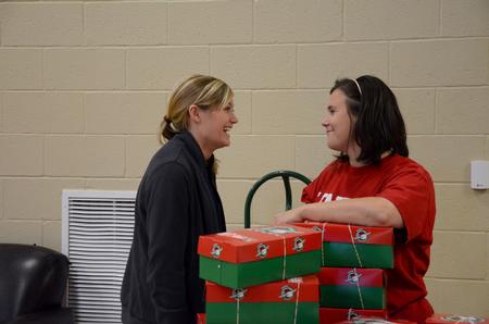 Andi Schreiber (left), senior family studies major, talks with Ashley Jackson, resident director, after packing boxes for Operation Christmas Child on Campus and Community Day.  - Photo by Anne Richoux
