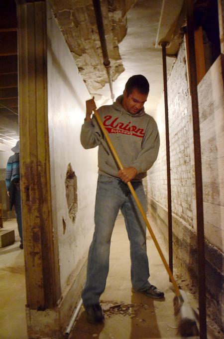 Colton Gebben, sophomore history major, sweeps floors at the Bemis Mill Village Museum during Campus and Community Day. - Photo by Zac Calvert