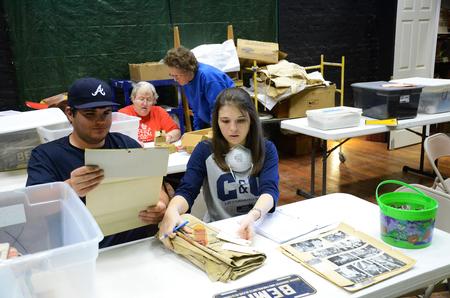 Jordan Haskins, junior computer science major, and Caitlin Roach, senior history major, help archive documents and photos at the Bemis Mill Village Museum during Campus and Community Day.  - Photo by Zac Calvert