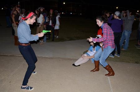Carin Lachiver, junior art major, and Tiffany Armstrong, junior psychology major, act like cowboys during Costume Coffee House at the Bowld Student Commons.  - Photo by Anne Richoux