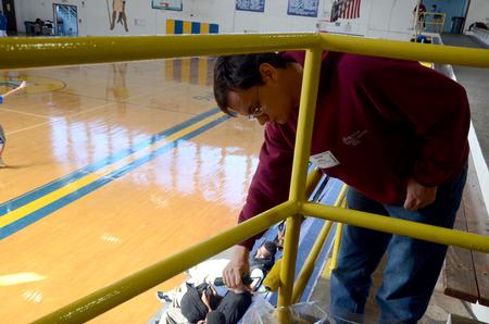 Carl Chmielewski, senior nursing major, paints the railings in the gym at North Side High School, during Union's ninth annual Campus and Community Day. - Photo by Ebbie Davis