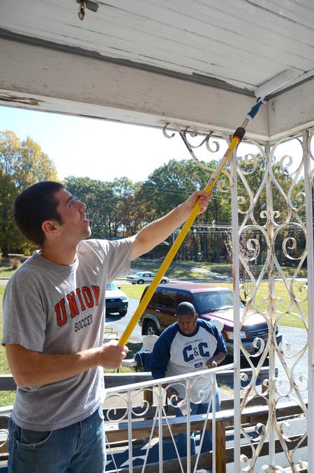 Jamie Fox, freshman math major, paints a local woman's porch as part of Union's ninth annual Campus and Community Day. - Photo by Ebbie Davis