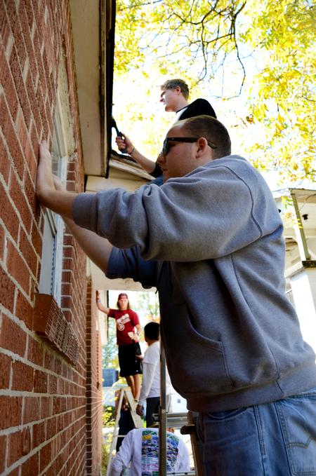 Jared Shumate, junior elementary education major, prepares to paint the trim of a home in Jackson as a part of Campus and Community Day. - Photo by Ebbie Davis