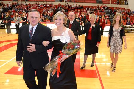 Andi Schreiber, senior family studies major, is escorted by her father, Mike Schreiber, after being crowned as the 2011 Homecoming Queen. - Photo by Jacob Moore