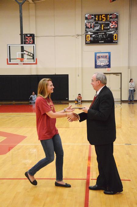 David S. Dockery, president of the university, presents the Community Service Award to Brittany Bural, junior social work major, during the homecoming weekend festivities.  - Photo by Zac Calvert