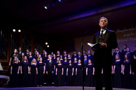 Chris Mathews, associate professor of music and department chair, leads the audience and the music department in a Christmas carol during "A Union Christmas." - Photo by Ebbie Davis