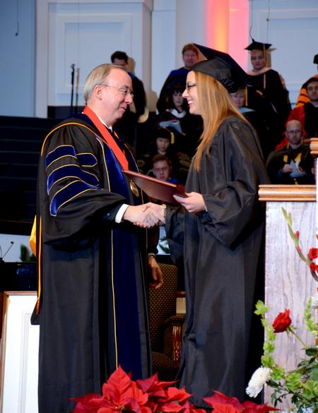 David S. Dockery, president of the university, presents Lindsey Bock, biology graduate, with her diploma at the 2011 Fall Commencement Services. - Photo by Ebbie Davis