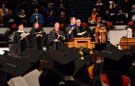 Chris Mathews, associate professor of music and department chair, leads graduates and their family and friends in a song during the 2011 Fall Commencement Services. - Photo by Jacob Moore