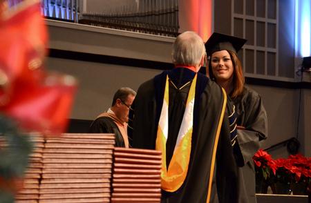 Brittany Marshall, business administration graduate, receives her diploma from David S. Dockery, president of the university, during the Fall Commencement Services held at West Jackson Baptist Church. - Photo by Jacob Moore