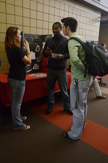 Junior social work majors, Natalie Schklar, Charles Currie, and Tyler Carr talk at the International Justice Mission table during the student organization fair. - Photo by Anne Richoux