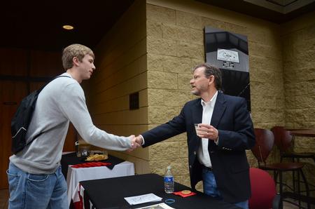 Michael Lewis, senior biology major, shakes hands with James Scruton, poet and head of the humanities division at Bethel College, after his poetry reading on campus. - Photo by Zac Calvert