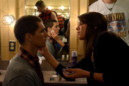 Elsie Krinsky, junior nursing major, helps apply stage makeup for Nick Fleming, freshman theatre/speech major, before Lambda Chi Alpha's performance at the 15th annual Variety Show. - Photo by Jacob Moore