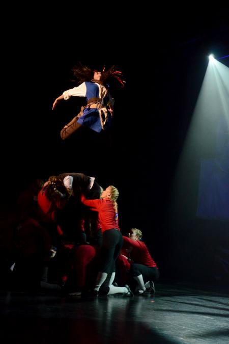 Claudia Velasco, junior accounting major, leaps into the air during an ending scene of Zeta Tau Alpha's performance at the 15th annual Variety Show. - Photo by Jacob Moore