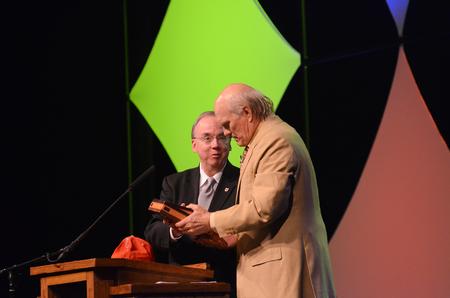 David S. Dockery, president of the university, presents keynote speaker Terry Bradshaw with a Holman Christian Standard Bible and a Union ballcap at the Roy L. White Legacy Golf & Gala. - Photo by Zac Calvert