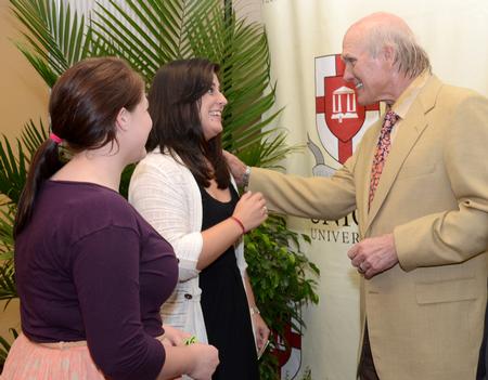 Terry Bradshaw, former NFL quarterback and current FOX Sports analyst and Heather Dragg, senior psychology major, discuss their love of sports and his stylish tie following the Roy L. White Legacy Golf & Gala.  - Photo by Ebbie Davis