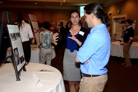 Holly Jay, junior sociology and intercultural studies double major, talks to Fonsie Guilaran, associate professor of physics, about her research during the poster presentations of the Scholarship Symposium. - Photo by Anne Richoux