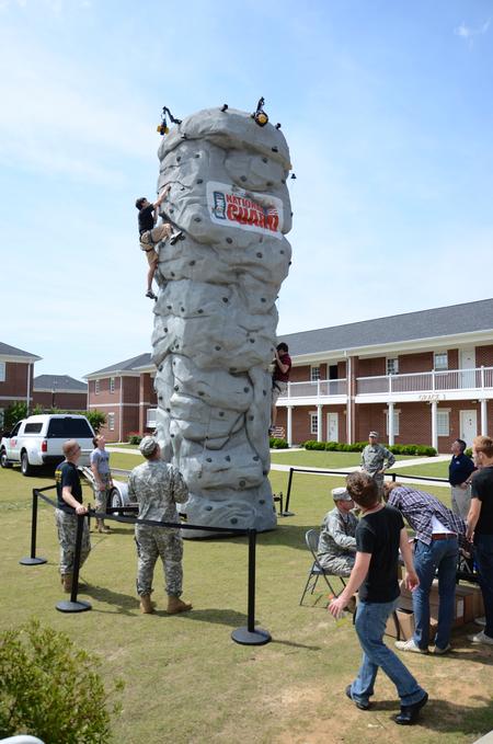 Students climb a rock tower provided by the National Guard during May Day, hosted by Student Activities Council in the Grace quad. - Photo by Jacob Moore