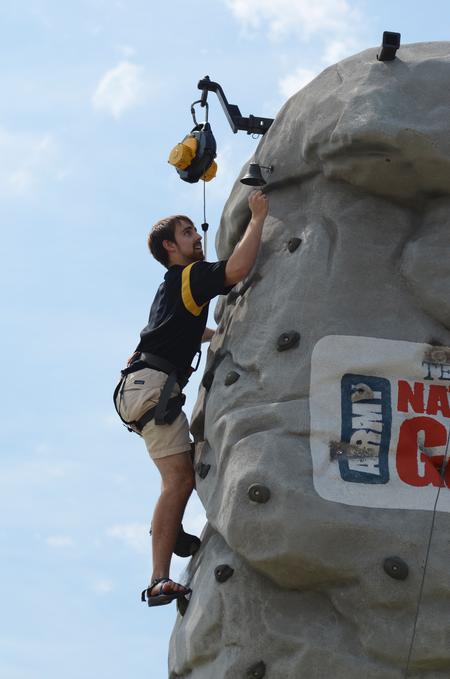 Daniel Stands, junior biblical studies in languages major, reaches the top of a rock climbing tower during May Day festivities. - Photo by Jacob Moore