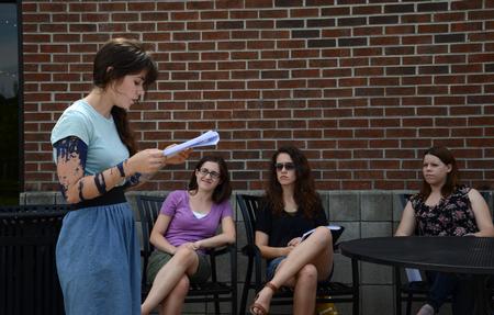 Ellen Cline, sophomore art major, presents an original work to members of the English department during the Scholarship Symposium. - Photo by Jacob Moore